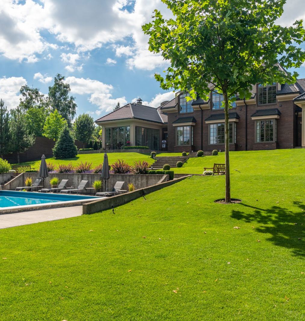 Finished residential landscape with mature trees, shrub beds and a manicured lawn